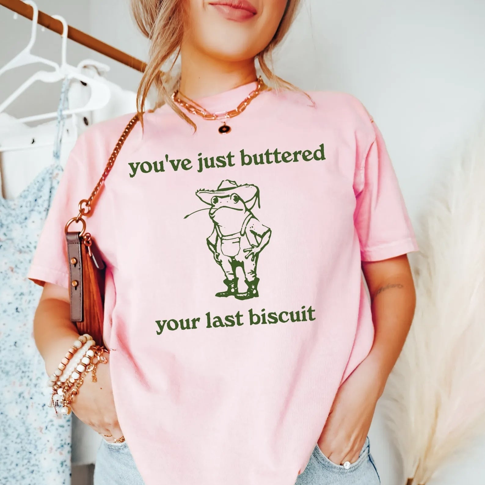 Pink T-shirt featuring cowboy frog and humorous southern phrase design.