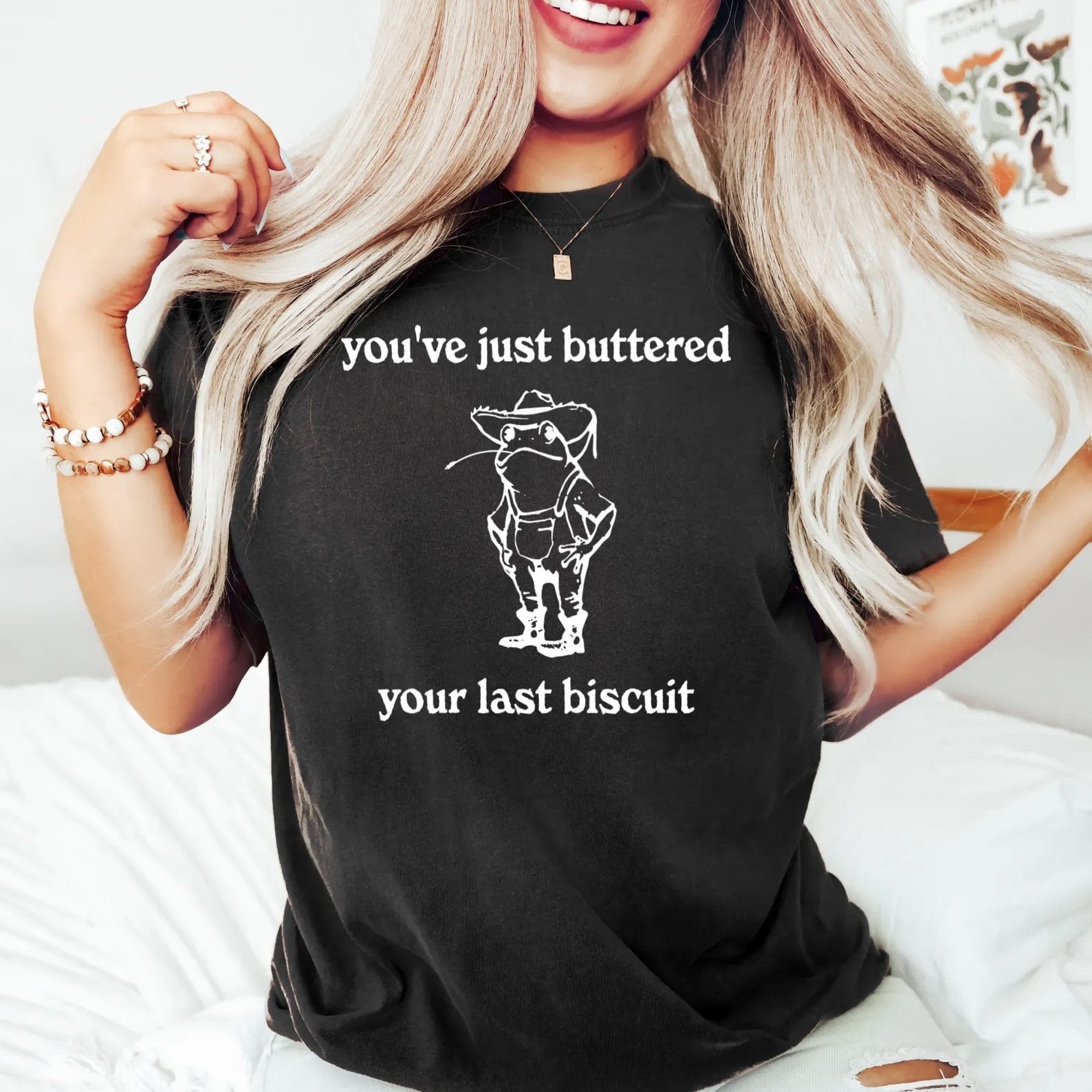 Charcoal T-shirt with "You've Just Buttered Your Last Biscuit" cowboy frog graphic.