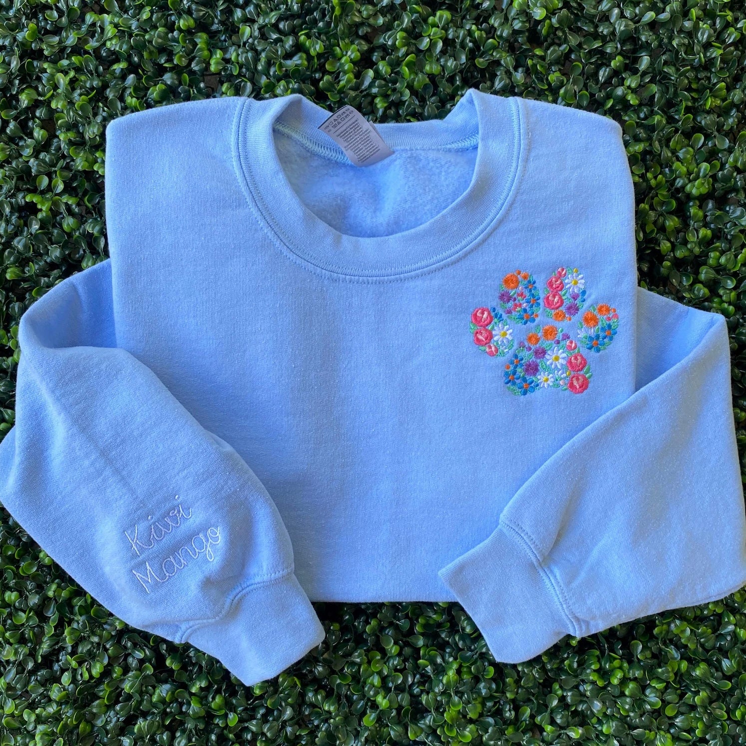 Cozy sweatshirt featuring colorful paw print and personalized details.
