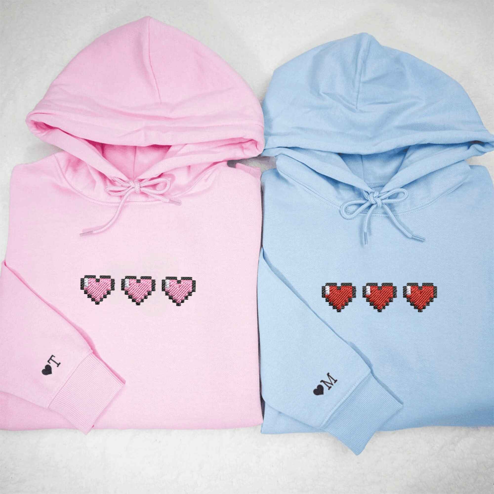 Matching Couple Hoodies with custom embroidered matching couple sweatshirts showing pixel hearts.
