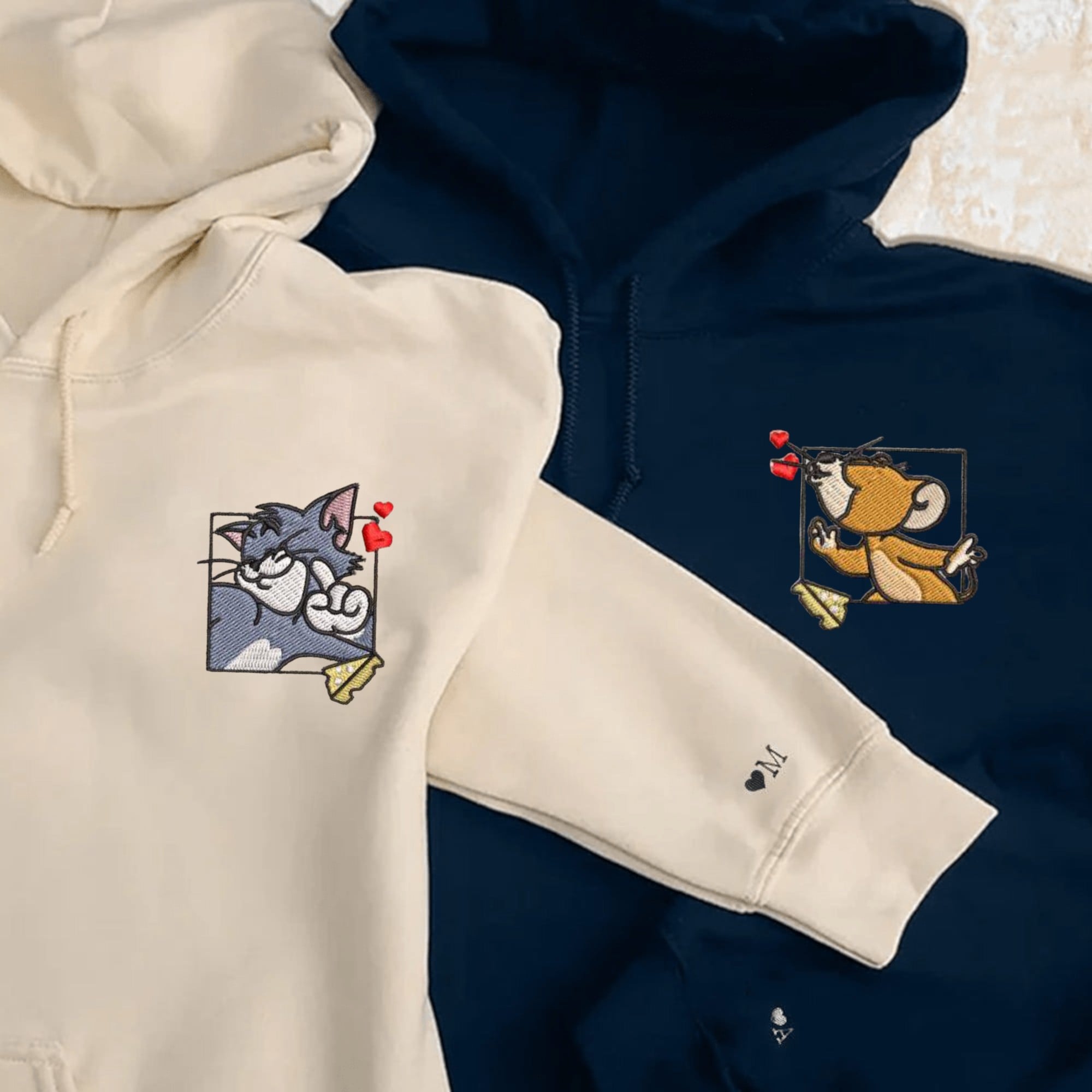 Matching Tom and Jerry hoodies for couples featuring playful embroidered patches.

