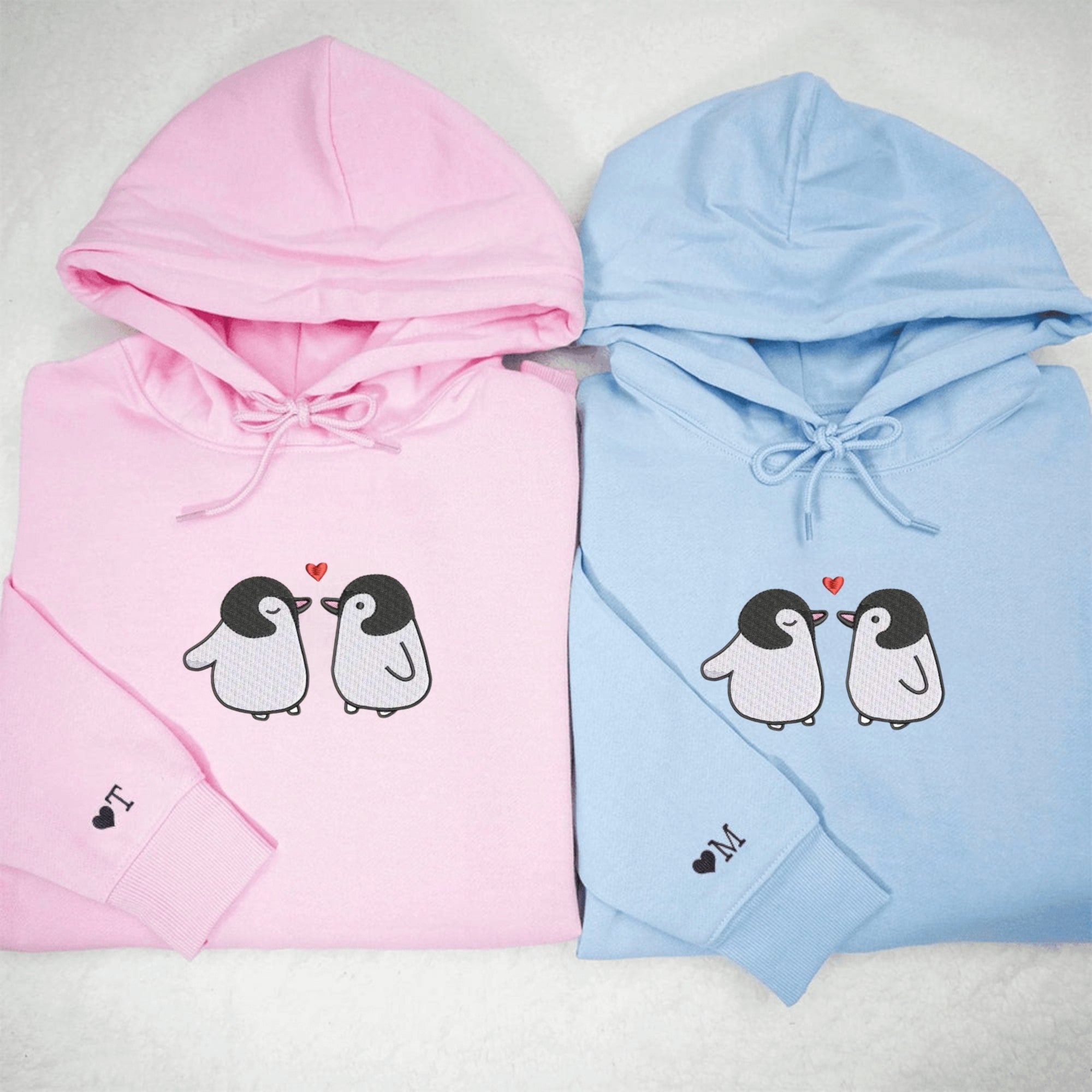 Adorable penguin couple hoodies for partners, with penguins facing each other.

