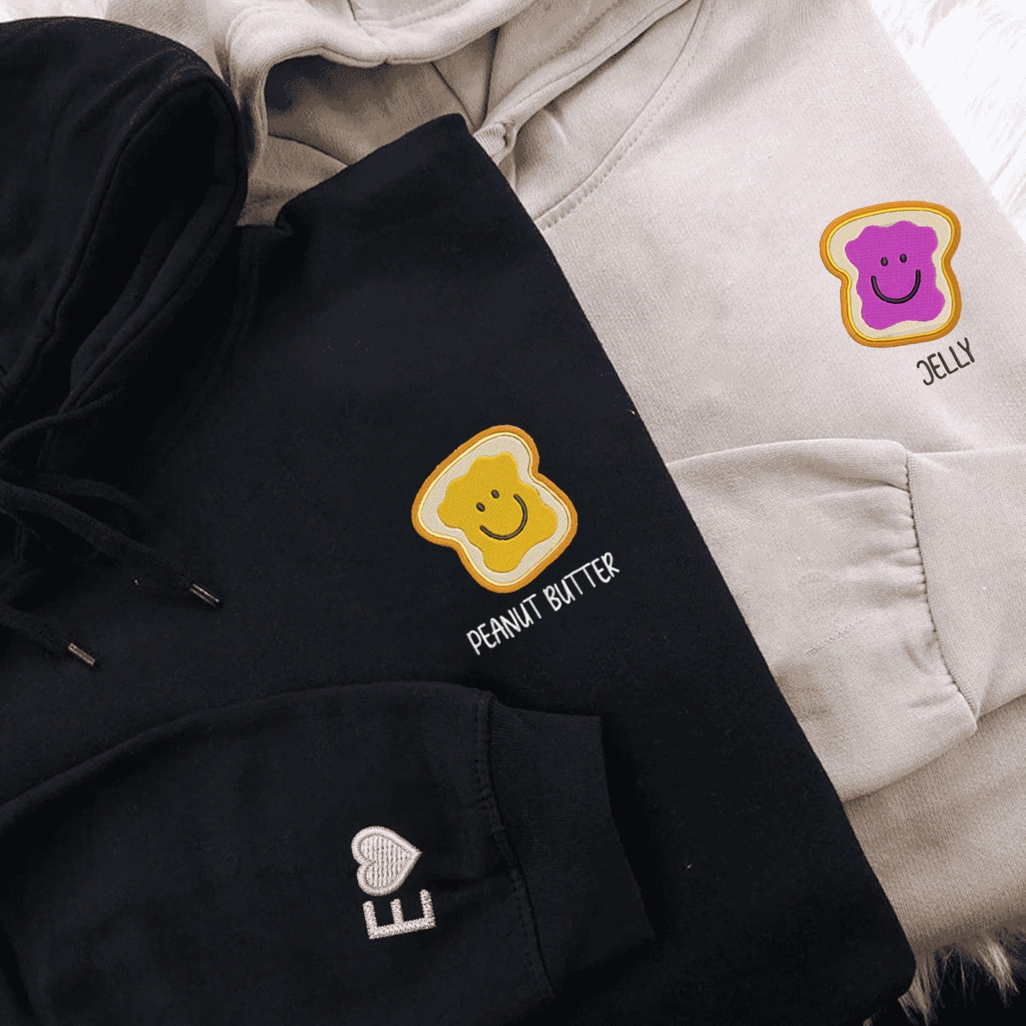 Peanut Butter and Jelly themed his and hers hoodies with smiling toast graphics.

