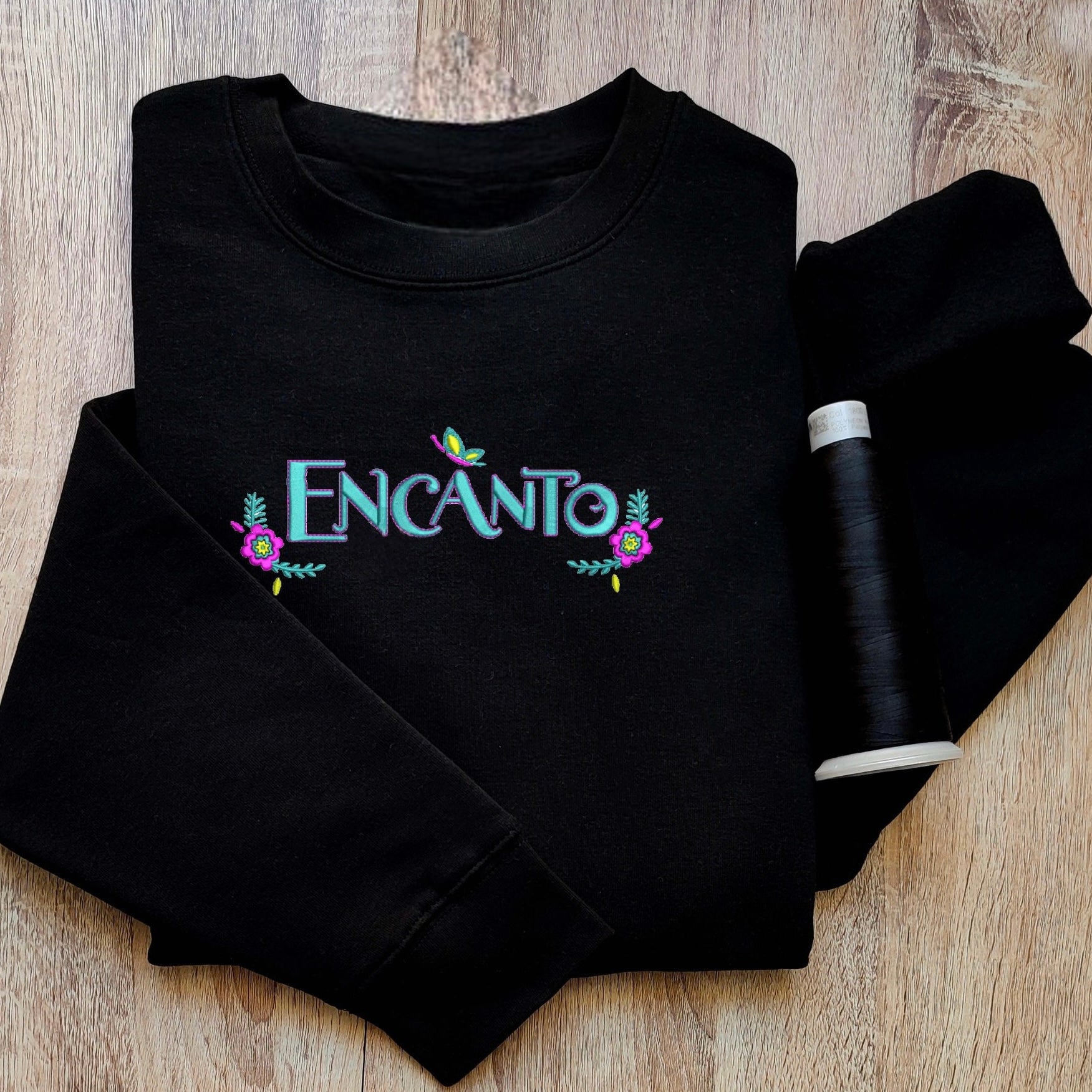 Custom embroidered graphic meme shirts showcasing a pink hoodie with floral embroidery, perfect for fans of funny meme t-shirts.
