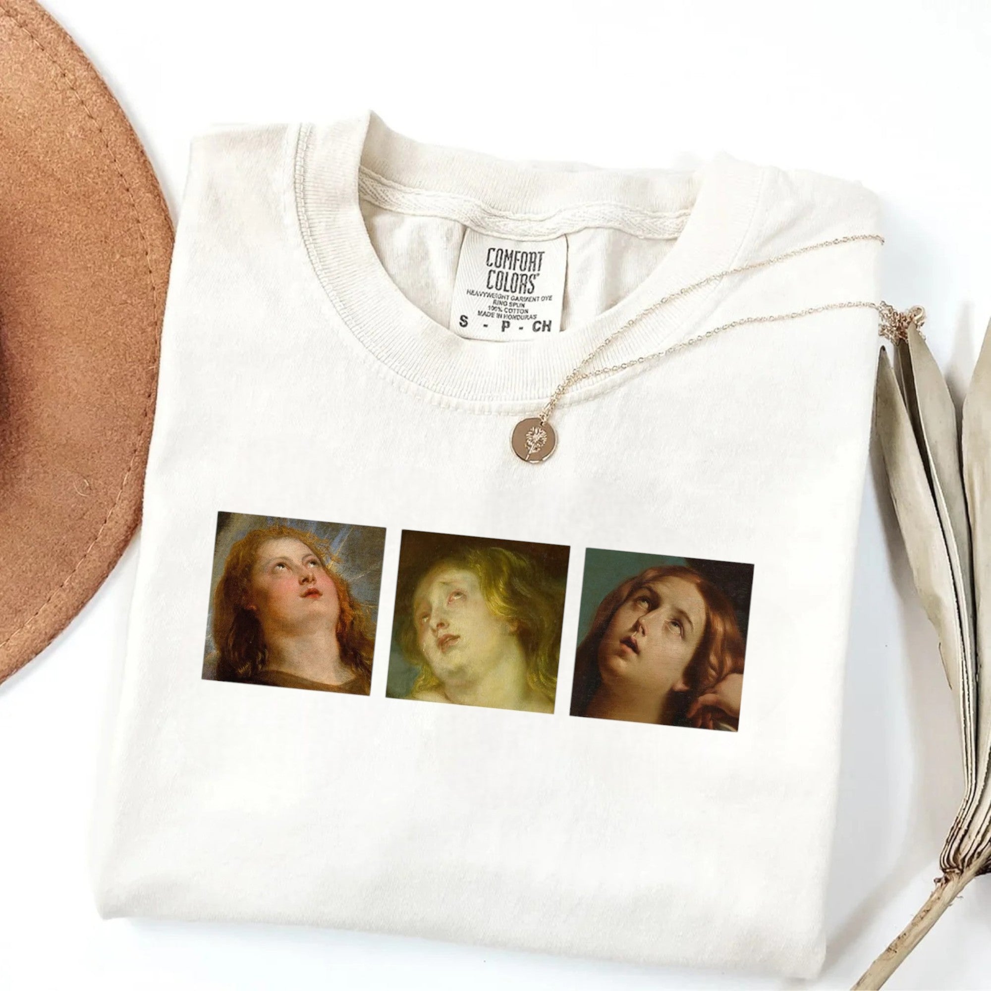 White graphic tee with Renaissance-style faces printed on the front