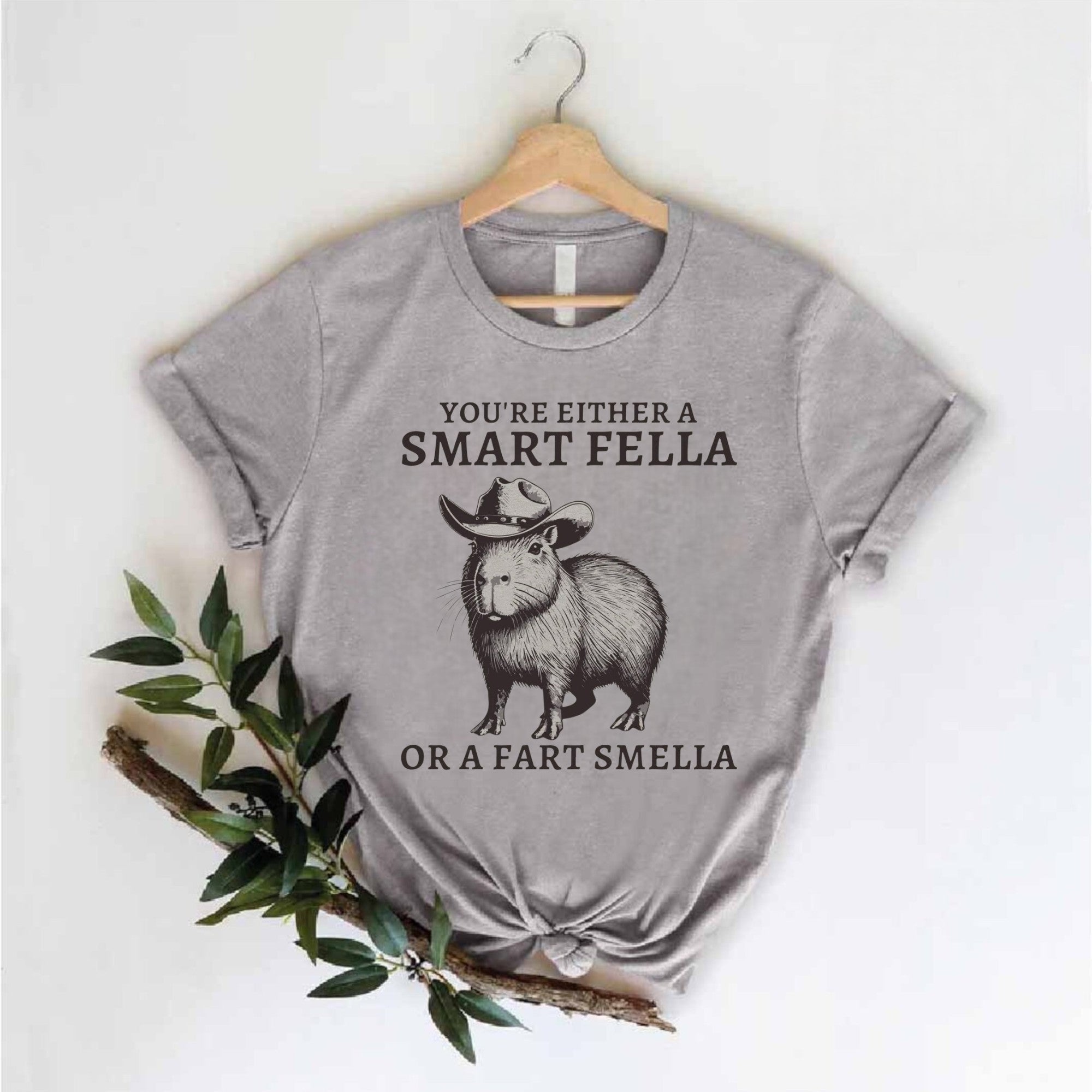 Light gray graphic tee featuring capybara with cowboy hat and slogan