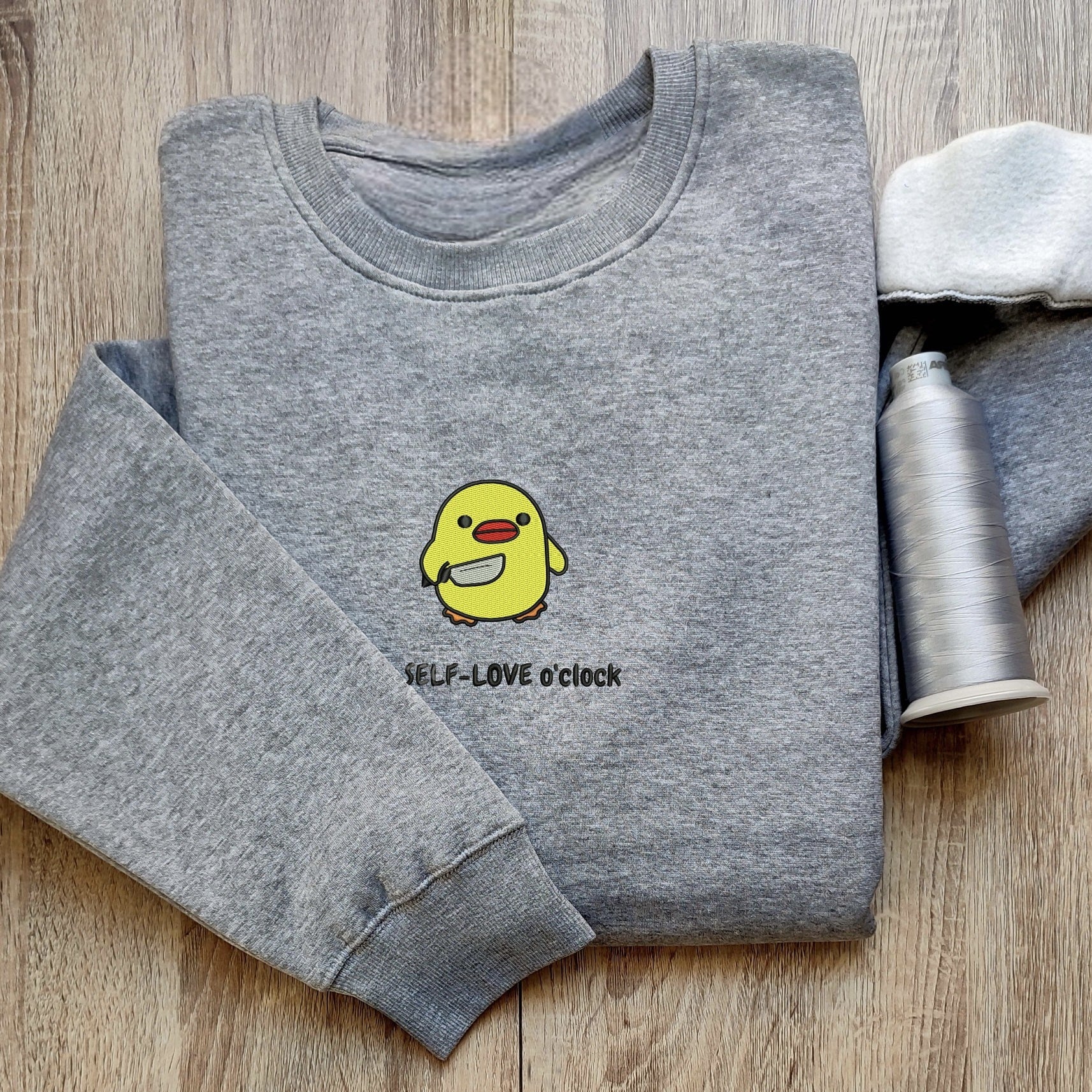 Custom embroidered graphic meme shirts showcasing a cute duck with a self-love message, perfect for fans of funny meme t-shirts.
