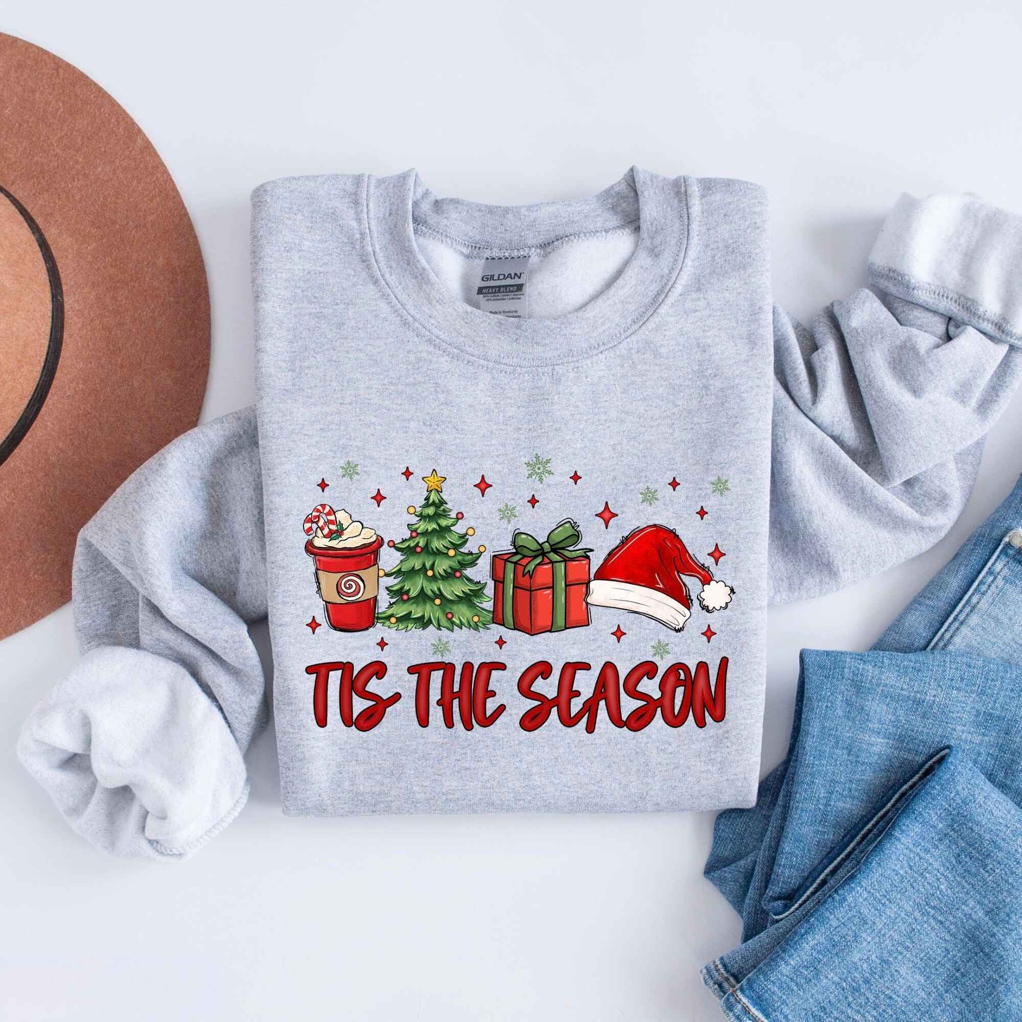 Cozy Christmas sweatshirt featuring Christmas tree, gifts, and Santa hat
