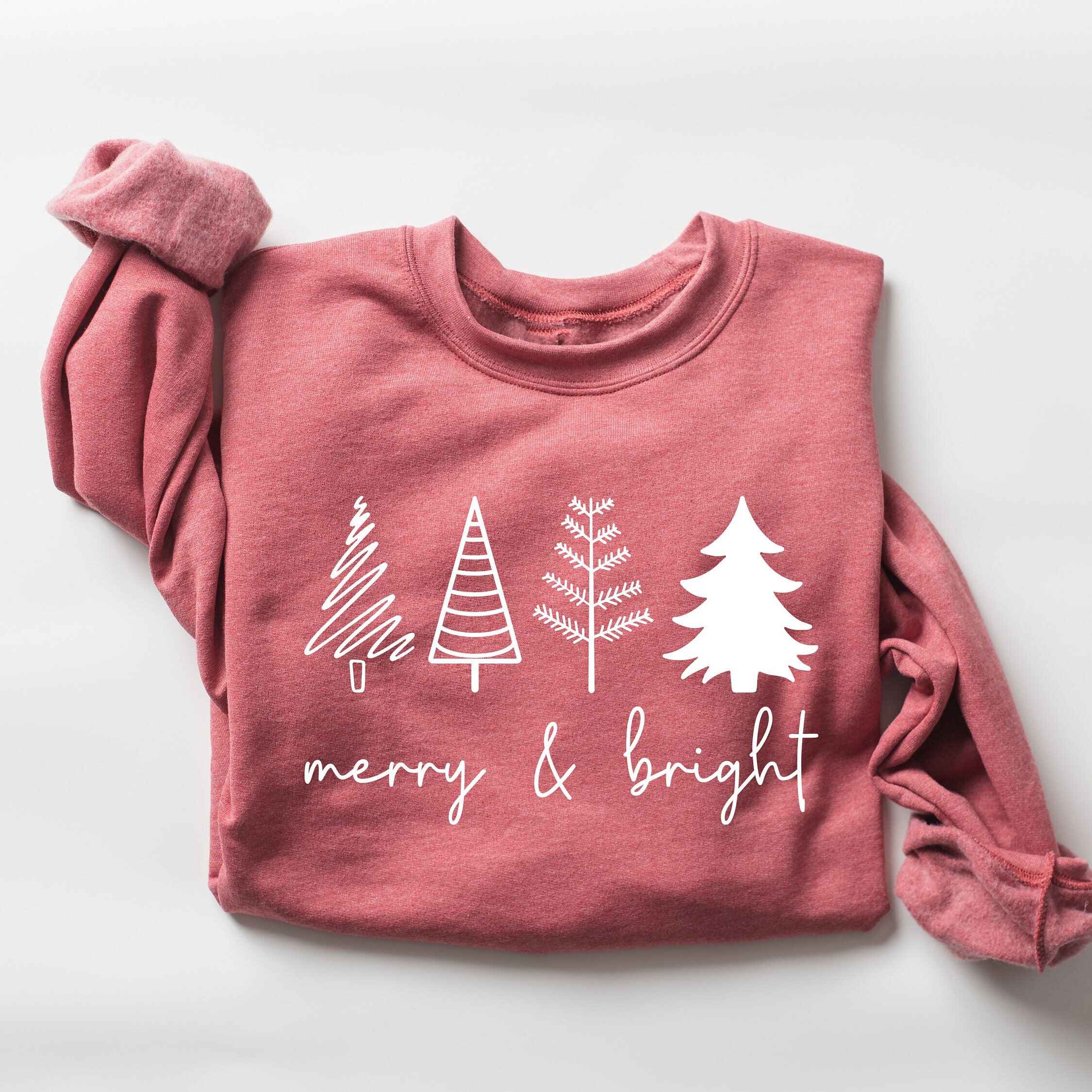 Holiday sweatshirt in burgundy with "Merry & Bright" text and tree illustrations
