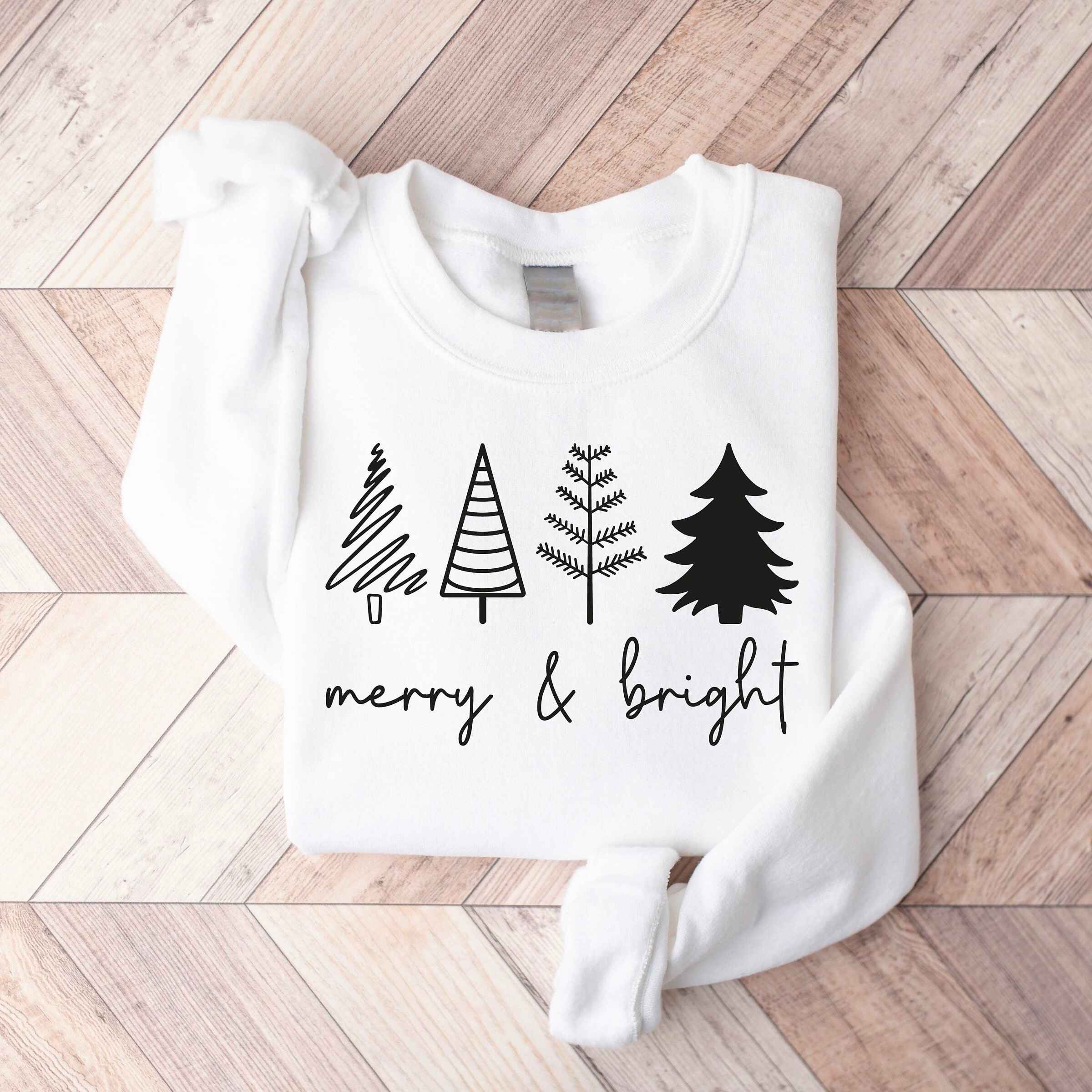 Holiday sweatshirt in burgundy with "Merry & Bright" text and tree illustrations
