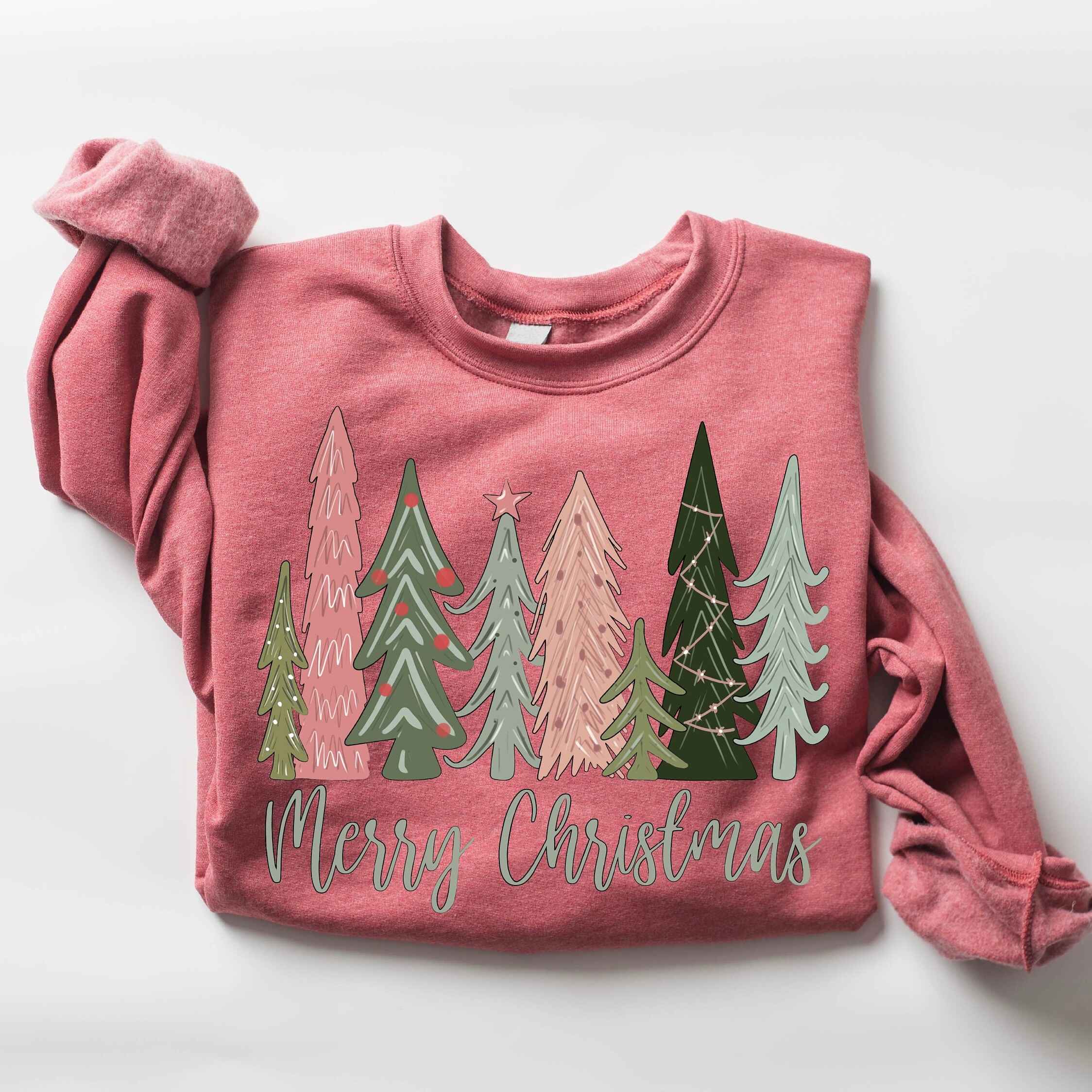 Festive holiday sweatshirt in green with "Merry Christmas" text and tree illustrations
