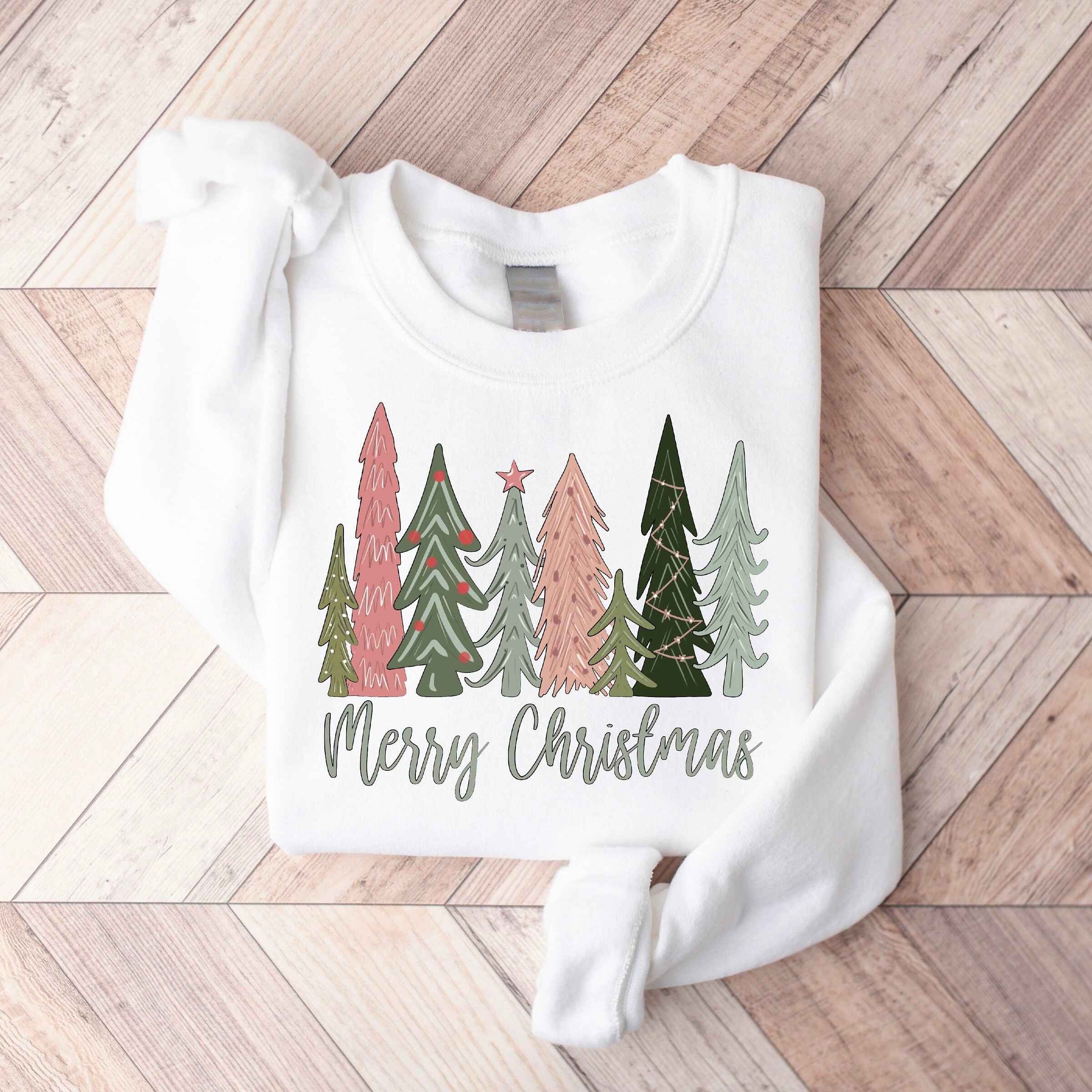 Festive holiday sweatshirt in green with "Merry Christmas" text and tree illustrations
