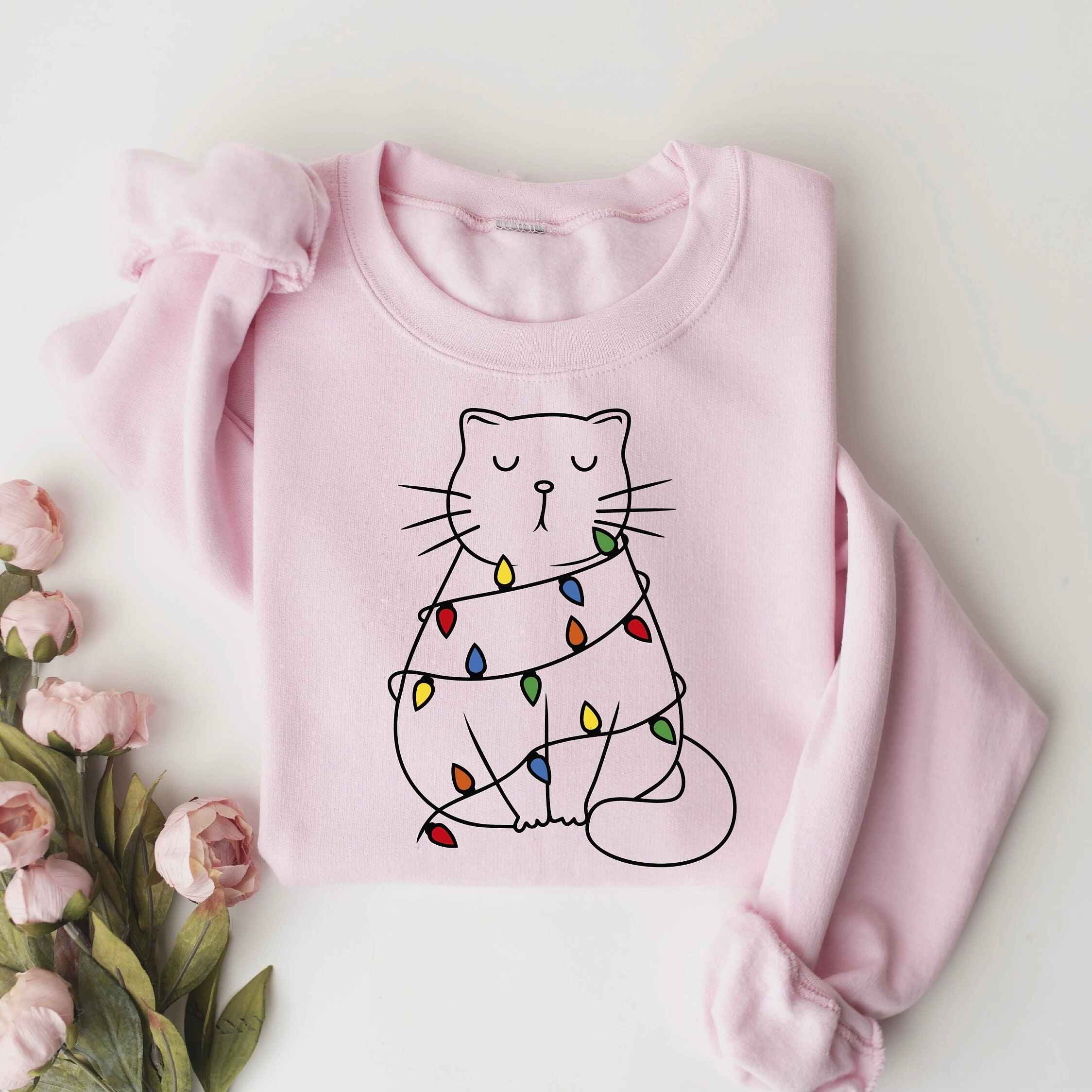 Christmas sweatshirt with a cat wrapped in holiday lights
