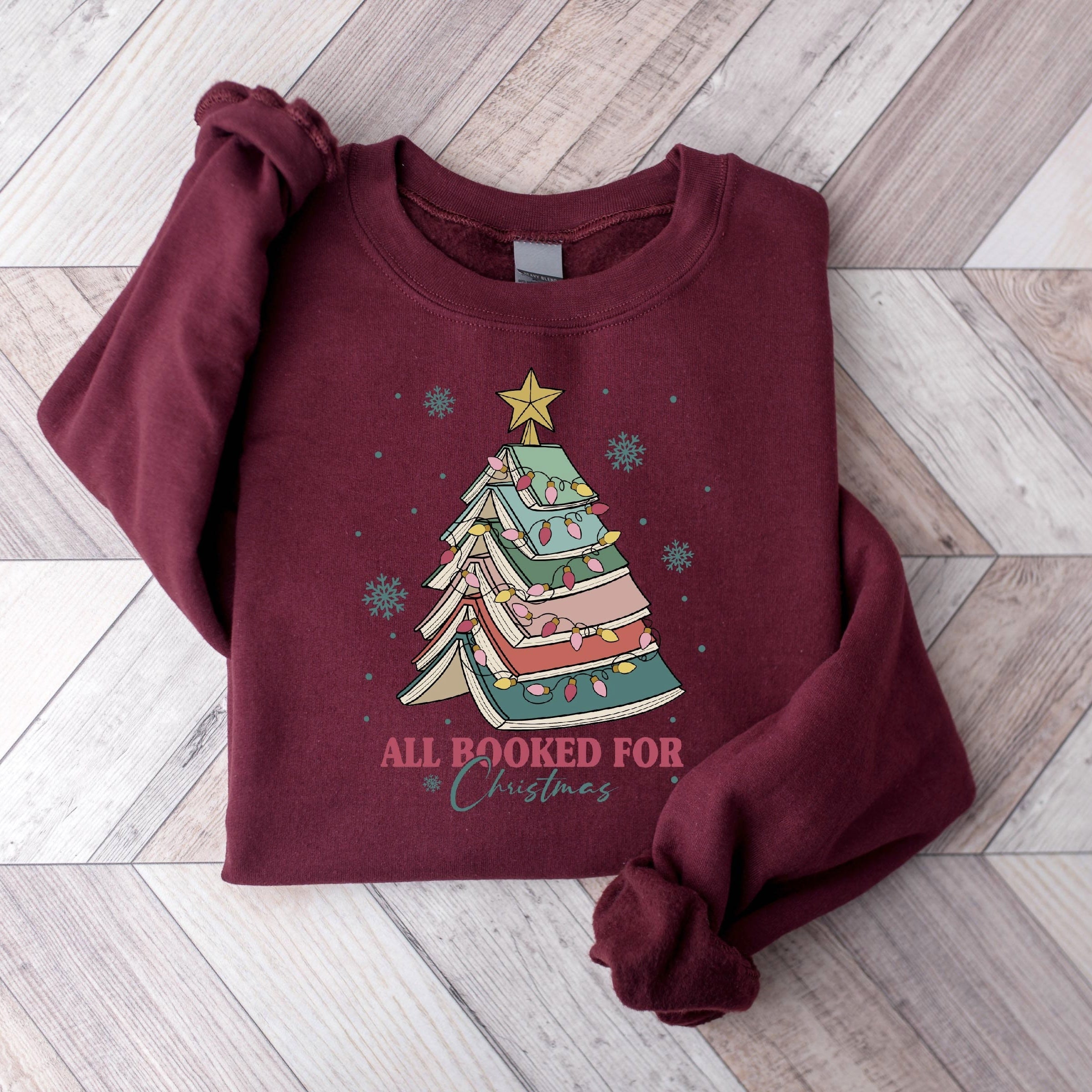 "All Booked for Christmas" sweatshirt with festive book tree design
