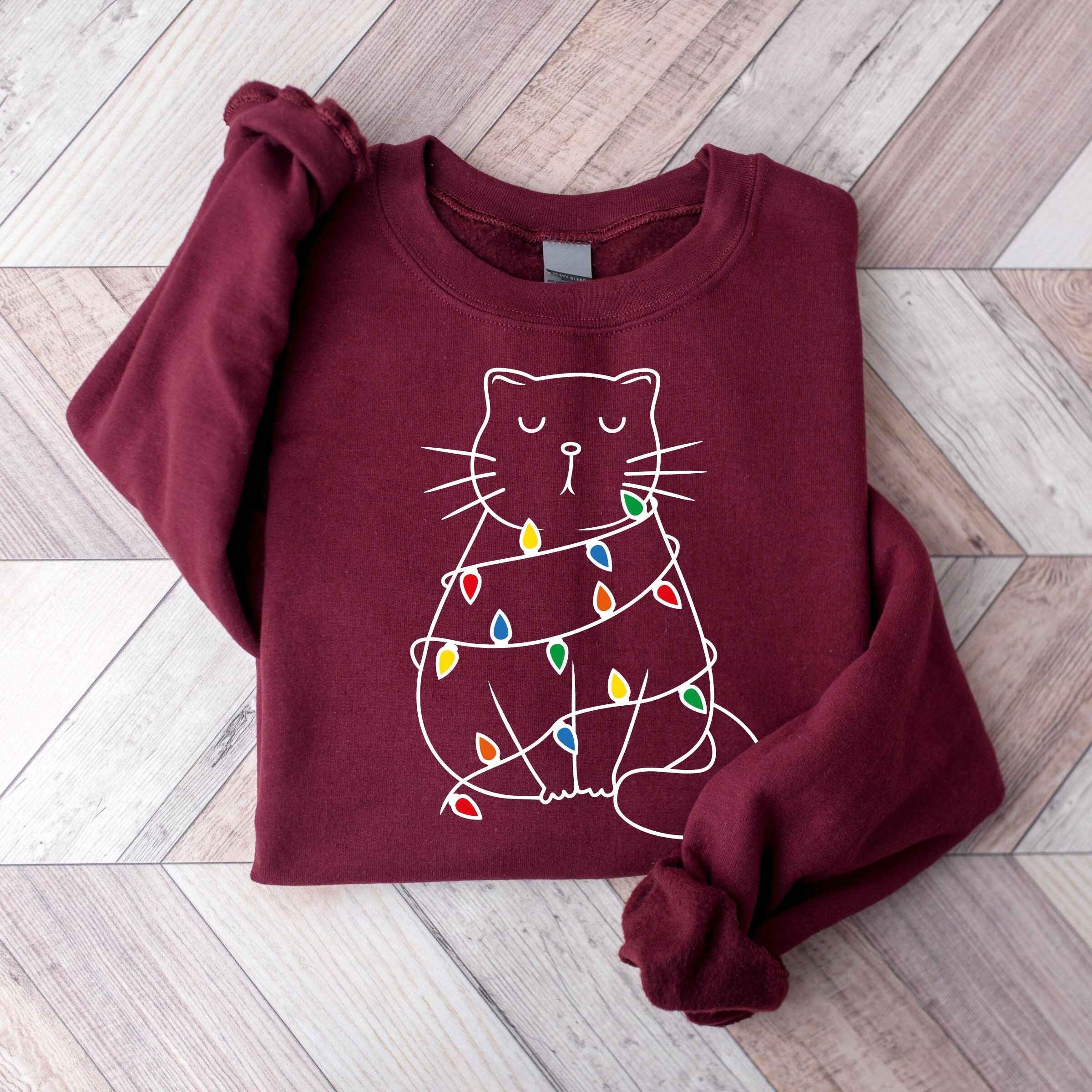 Christmas-themed sweatshirt with adorable cat illustration
