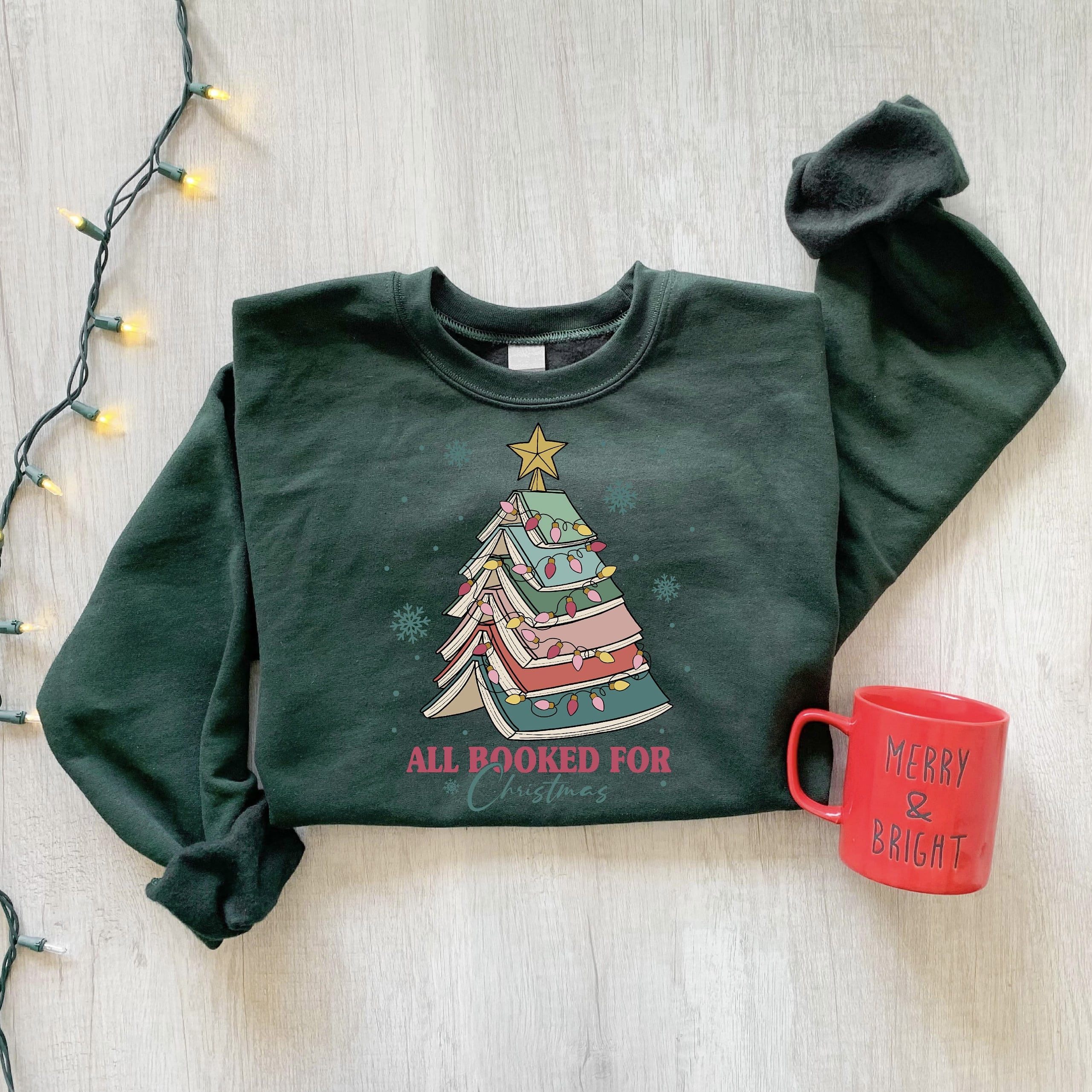 Cozy holiday sweatshirt featuring a book stack Christmas tree
