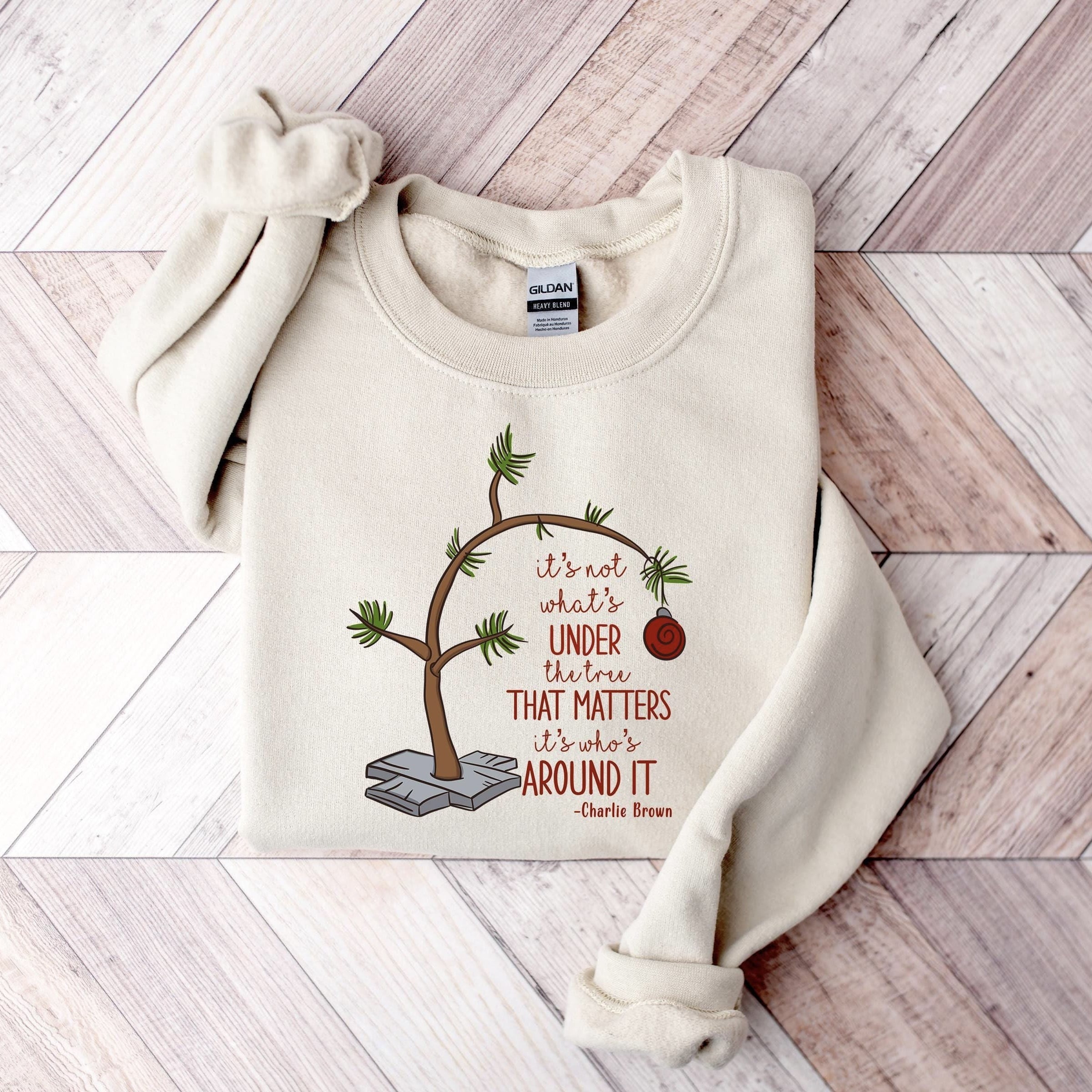 Charlie Brown-inspired festive sweatshirt with a minimalist tree and heartfelt holiday quote.





